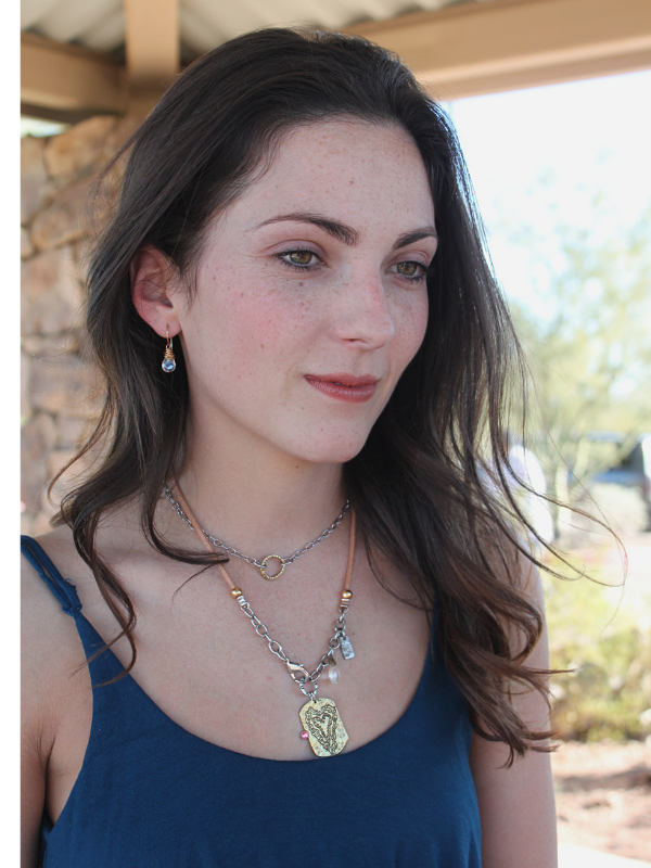 heart necklace on dark haired model outside